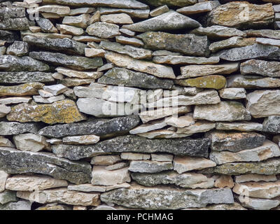 Parete di roccia calcarea fatta di asciugare i pezzi impilati piastrelle. Telaio completo immagine come sfondo. Foto Stock