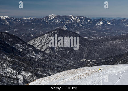 Un cavaliere solitario sulla sommità delle montagne coperte di neve nella Riserva Naturale Nazionale in Adygea, Russia. Benvenuti in Russia. Foto Stock