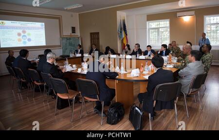 180731-N-BK DEVESELU435-0033, Romania (31 luglio 2018) Col. Razvan Bratulescu, comandante di base per i Romeni 99th base militare con il cap. Charlos Washington, comandante navale per il meccanismo di sostegno Deveselu, dare una base breve ai membri dalla Dieta giapponese durante un tour di base. NSF Deveselu AAMDS e Romania sono co-localizzato con il rumeno 99th Base Militare e gioca un ruolo chiave nel missile balistico di difesa in Europa orientale. (U.S. Foto di Marina di Massa lo specialista di comunicazione 1a classe Jeremy Starr/rilasciato) Foto Stock