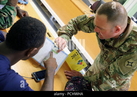 Sgt. 1. Classe Robby E. Creech, con il Florida Guardia Nazionale C-ERFP, assiste gli stati di Saint Kitts e Nevis Fire Servizi di salvataggio cercare una targhetta hazmat numero nella risposta di emergenza manuale. Membri del FLNG C-ERFP stanno sostenendo il membro del programma di partnership di formazione locale di emergenza agenzie di risposta sulla ricerca e le operazioni di estrazione in Saint Kitts e Nevis, Luglio 28 2018. Foto Stock