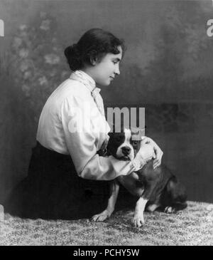 Helen Keller, ritratto seduto sul pavimento tenendo un bulldog francese cercando di destra nel 1902. Helen Keller (Giugno 27, 1880 - Giugno 1, 1968) era un autore americano, attivista politico, e docente. Lei è stato il primo sordo-persona cieca per guadagnare un bachelor del grado di arti. Foto Stock