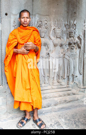 Angkor Wat, Cambogia - 11 Gennaio 2018: Monk si fermò da un bassorilievo immagine. I monaci spesso può essere visto in tutto il complesso. Foto Stock