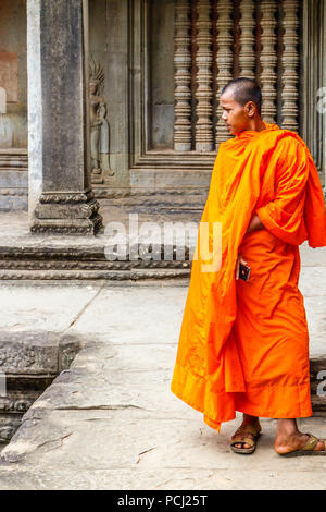 Angkor Wat, Cambogia - 11 Gennaio 2018: Monk si fermò da un bassorilievo immagine. I monaci spesso può essere visto in tutto il complesso. Foto Stock