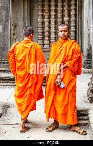 Angkor Wat, Cambogia - 11 Gennaio 2018: Monk si fermò da un bassorilievo immagine. I monaci spesso può essere visto in tutto il complesso. Foto Stock