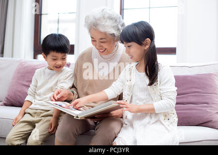Allegro nonna cinese e i nipoti guardando album di foto Foto Stock