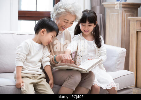 Allegro nonna cinese e i nipoti guardando album di foto Foto Stock