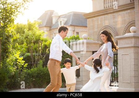 Felice giovane famiglia cinese a giocare al di fuori Foto Stock