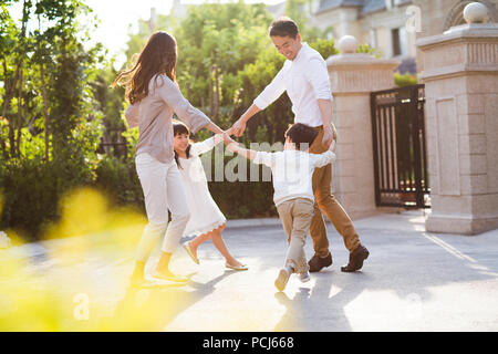 Felice giovane famiglia cinese a giocare al di fuori Foto Stock