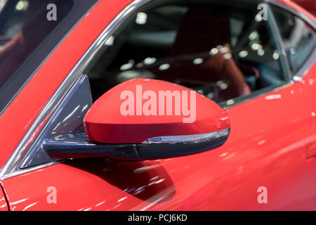 Red vista laterale specchio con red sport auto moderna. Foto Stock
