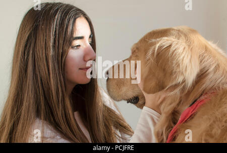 Ragazza di accarezzare il suo golden retriever cane Foto Stock