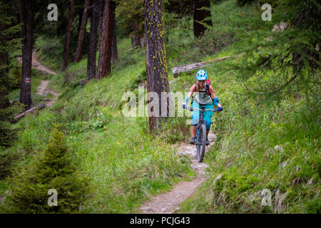 Woman mountain bike nelle alpi svizzere vicino a Davos, Grigioni, Svizzera Foto Stock