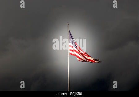 La bandiera americana Vola di fronte minacciosa guardando le nuvole Foto Stock