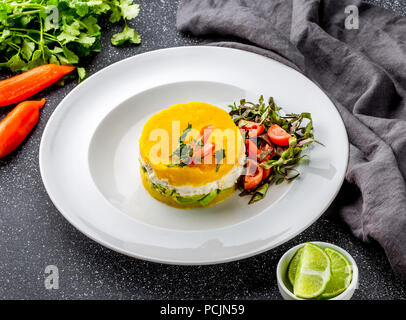 La cucina peruviana. Causa rellena de pollo. Pollo causa rellena. Peruviano tradizionale piatto di patate gialle, pollo, Avocado su piastra bianca Foto Stock