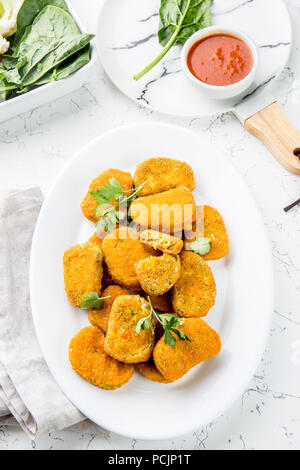 Sana pepite vegetariano con carote, cavolfiori e spinaci. Pepite di vegetali. Cibo vegan. Vista superiore, sfondo bianco Foto Stock