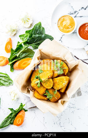 Sana pepite vegetariano con carote, cavolfiori e spinaci. Pepite di vegetali. Cibo vegan. Vista superiore, sfondo bianco Foto Stock