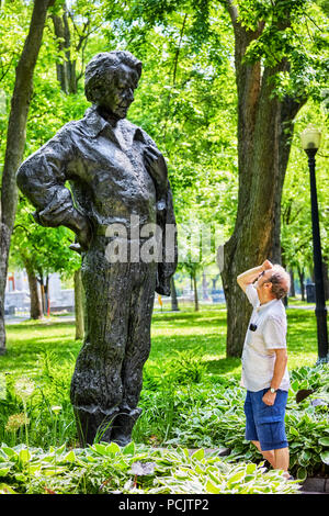 Montreal, Canada - Giugno, 2018. Un maschio caucasico guardando il monumento statua di Felix Leclerc de La Fontaine Park, Montreal, Canada. Foto Stock