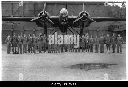 Immagine da l'album fotografico di Oberleutnant Wilhelm Gallia: Willi Gallia (8 piedi da sinistra con il suo alsaziano 'Karo') con gli ufficiali ed equipaggi di NCO di 1. Staffel, Küstenfliegergruppe 106, pone di fronte a una delle unità Heinkel He 115B-1 floatplanes. Probabilmente preso in primavera 1941. Foto Stock