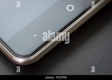 Uno smartphone si appoggia su un nero office desk close-up. Foto Stock