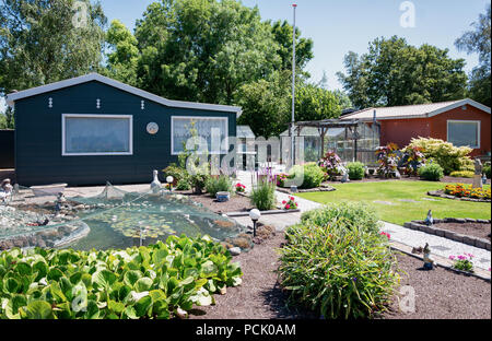 Zaandam, Paesi Bassi, 2 Luglio 2018: Tettoia da giardino con serra e stagno circondato da un bellissimo giardino decorativo in Paesi Bassi Foto Stock