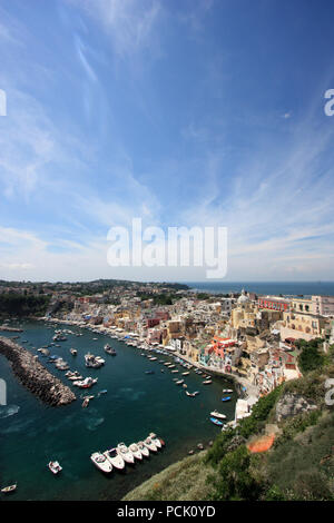 Vista panoramica del lungomare di Corricella a Procida, Golfo di Napoli, Italia, con il vivacemente colorate case dipinte in diverse sfumature pastello Foto Stock