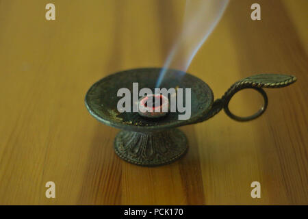 Bruciare incenso in bronzo tazza marrone sul tavolo di legno Foto Stock