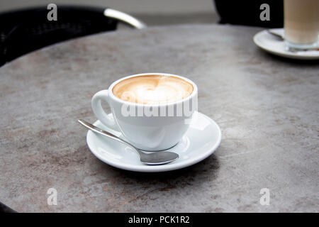 Servita tazza di cappuccino caldo il caffè con la schiuma e cucchiaio Foto Stock