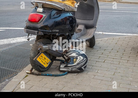 Malaga, Spagna - 24 febbraio 2018. Abbandonato scooter con casco su strada Foto Stock