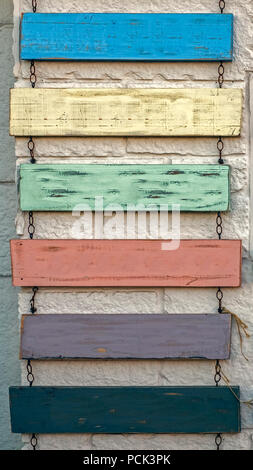 Vuoto segno rustico appeso su catene contro il vecchio muro Foto Stock