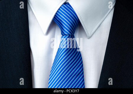 Close-up di un blu cravatta a strisce con withe camicia e imprenditore scuro tuta. Foto Stock