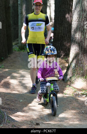 Una bambina (3 anni) in sella il suo equilibrio bike nel Regno sentieri atEast Burke, Vermont, USA Foto Stock