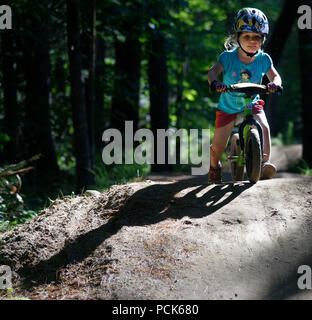 Una bambina (3 anni) in sella il suo equilibrio bike nel Regno sentieri atEast Burke, Vermont, USA Foto Stock