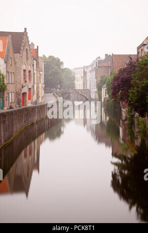 Un canale a Gouden-Handrei a Bruges in una tipica giornata di nebbia con la riflessione. Il giorno di esposizione lunga shot. Foto Stock