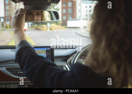 autista donna che regola lo specchietto retrovisore di un'auto. concetti di  viaggio, viaggio e trasporto di sicurezza 25498997 Stock Photo su Vecteezy