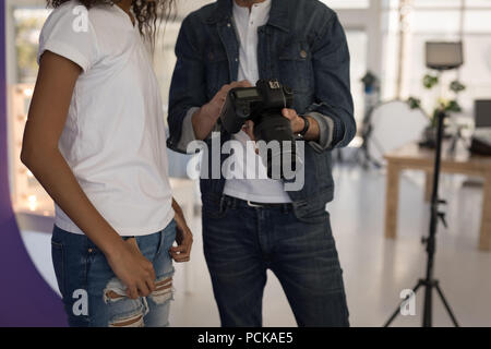 Il fotografo che mostra le foto di moda su un modello di fotocamera digitale Foto Stock