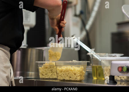 Lo Chef miscelando gli ingredienti in scatole Foto Stock