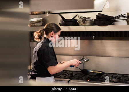 Lo Chef la miscelazione del vegetale in padella durante la cottura Foto Stock