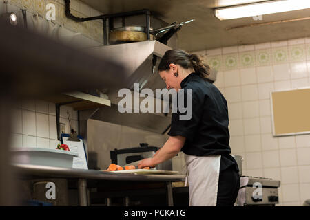 Lo Chef tritare verdure in cucina commerciale Foto Stock