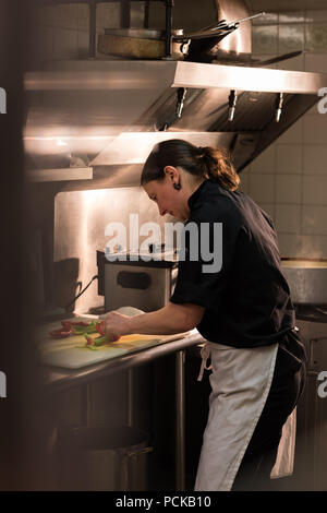 Chef vegetale di trinciatura in cucina commerciale Foto Stock