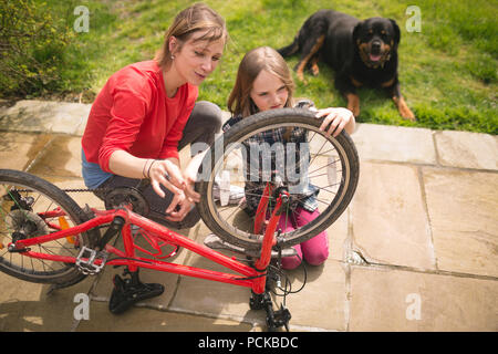 Madre e figlia riparazione bicicletta insieme Foto Stock