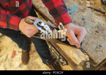 Falegname maschio utilizzando lo strumento piano in officina Foto Stock