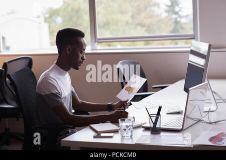 Executive Office con disegno della vettura la scrittura sul blocco note sulla sua scrivania Foto Stock