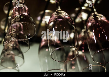 Bicchieri vuoti su sfondo nero. Illuminazione artificiale crea Riflessi e abbagliamenti in vetro. Sfondo astratto con copia spazio. Foto Stock