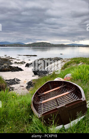 Spiaggia di sabbia e costa rocciosa di Isola di Iona con spiaggiata barca e vista di Fionnphort Isle of Mull Suono di Iona Ebridi Interne in Scozia UK Foto Stock