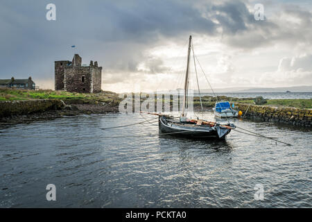Il castello di Portencross, Portencross, Ayrshire, in Scozia, Regno Unito, 7 novembre 2017. Portencross Castello con una barca ancorata nella piccola harbou Foto Stock