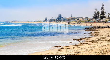 Blu oceano, litorale sabbioso e case di Swakopmund tedesco città coloniale, Namibia Foto Stock