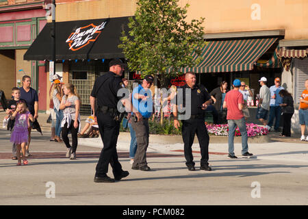 Gli ufficiali di polizia dirigere traffico in preparazione per l'annuale Cruz In antichi e vintage parata del veicolo nel centro cittadino di Montague, Michigan, Stati Uniti d'America. Foto Stock