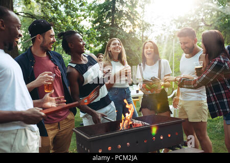Gruppo di amici fare barbecue nel cortile. concetto circa il bene e stato d'animo positivo con gli amici Foto Stock