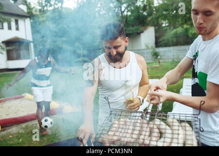 Gruppo di amici fare barbecue nel cortile. concetto circa il bene e stato d'animo positivo con gli amici