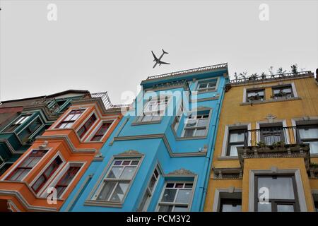 Un piano è volare su case di Balat in un giorno nuvoloso Foto Stock