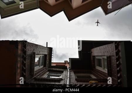 Un piano è volare su case di Balat in un giorno nuvoloso Foto Stock